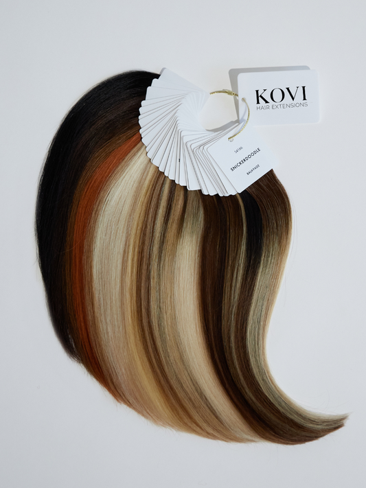 A complete KOVI Hair color ring featuring an extensive range of hair extension shades, from icy blondes to rich brunettes and vibrant fashion tones. The high-quality human hair swatches are neatly arranged on a ring, allowing for accurate color matching and customization for seamless hair extension blending.