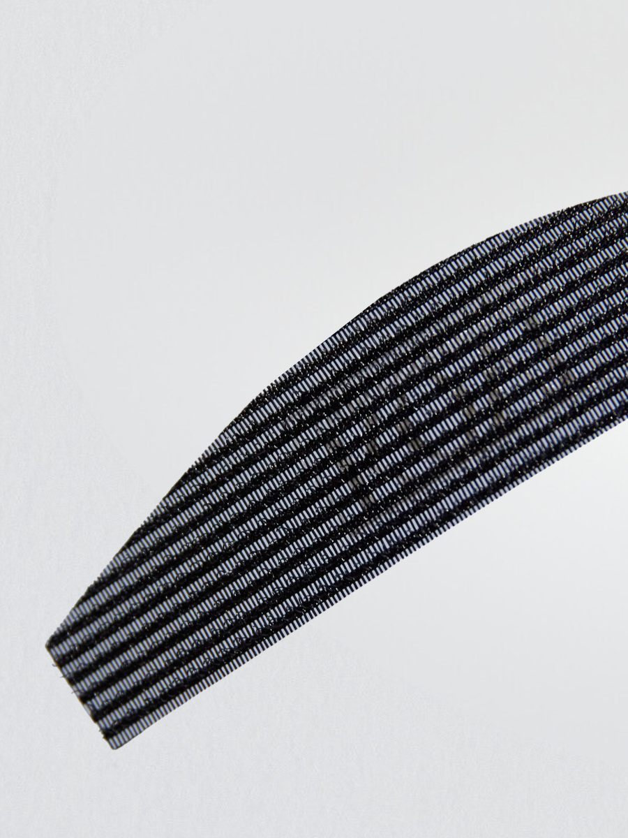 A detailed close-up of KOVI curved hair grippers showcasing the textured, non-slip surface. The lightweight yet strong grip holds hair in place, preventing flyaways during hair extension application.