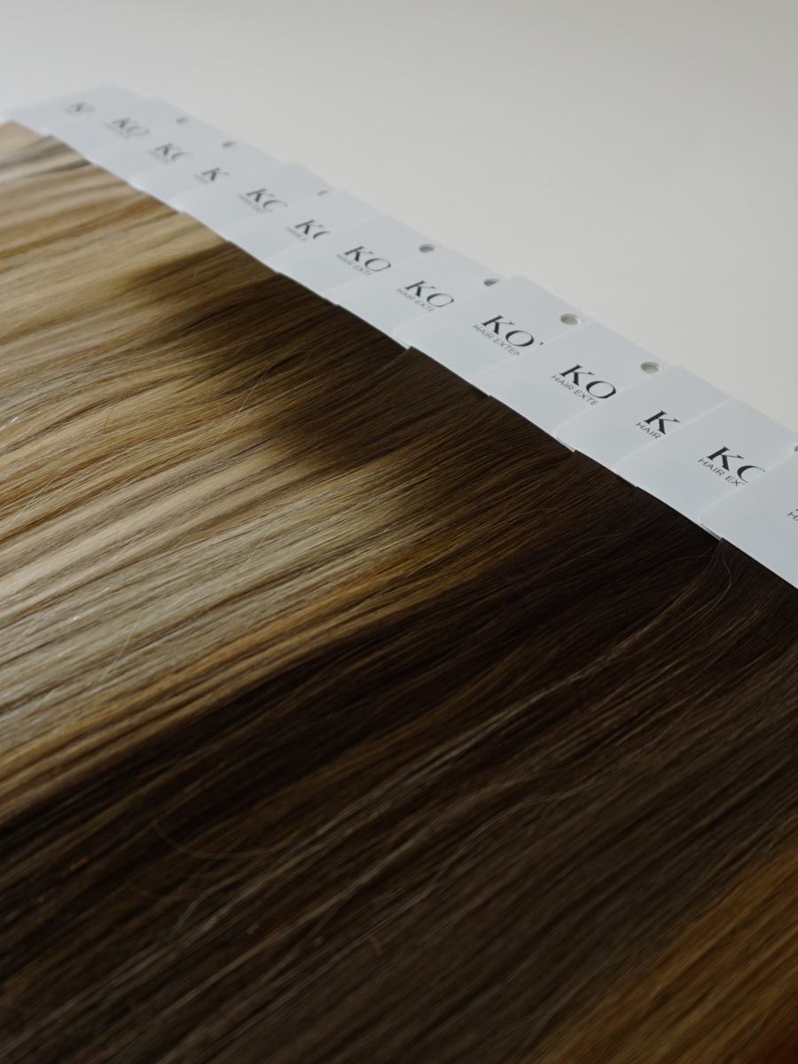 A full set of KOVI Hair color ring swatches displayed in a gradient layout, showcasing a variety of professional hair extension shades. From warm blondes to deep brunettes, these 100% human hair samples provide an accurate color match for seamless extension blending. Perfect for stylists and salons selecting the ideal extension tone for clients.