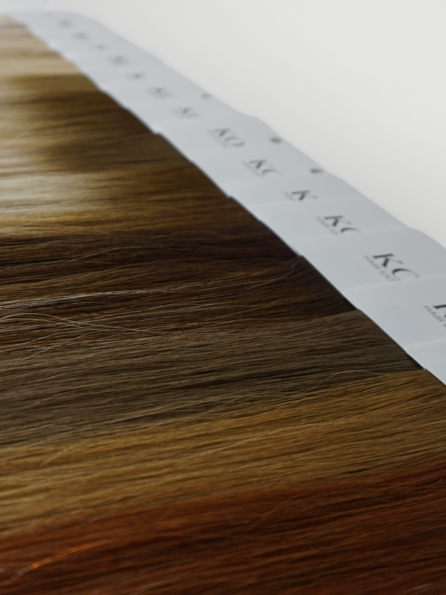 A full set of KOVI Hair color ring swatches displayed in a gradient layout, showcasing a variety of professional hair extension shades. From warm blondes to deep brunettes, these 100% human hair samples provide an accurate color match for seamless extension blending. Perfect for stylists and salons selecting the ideal extension tone for clients.